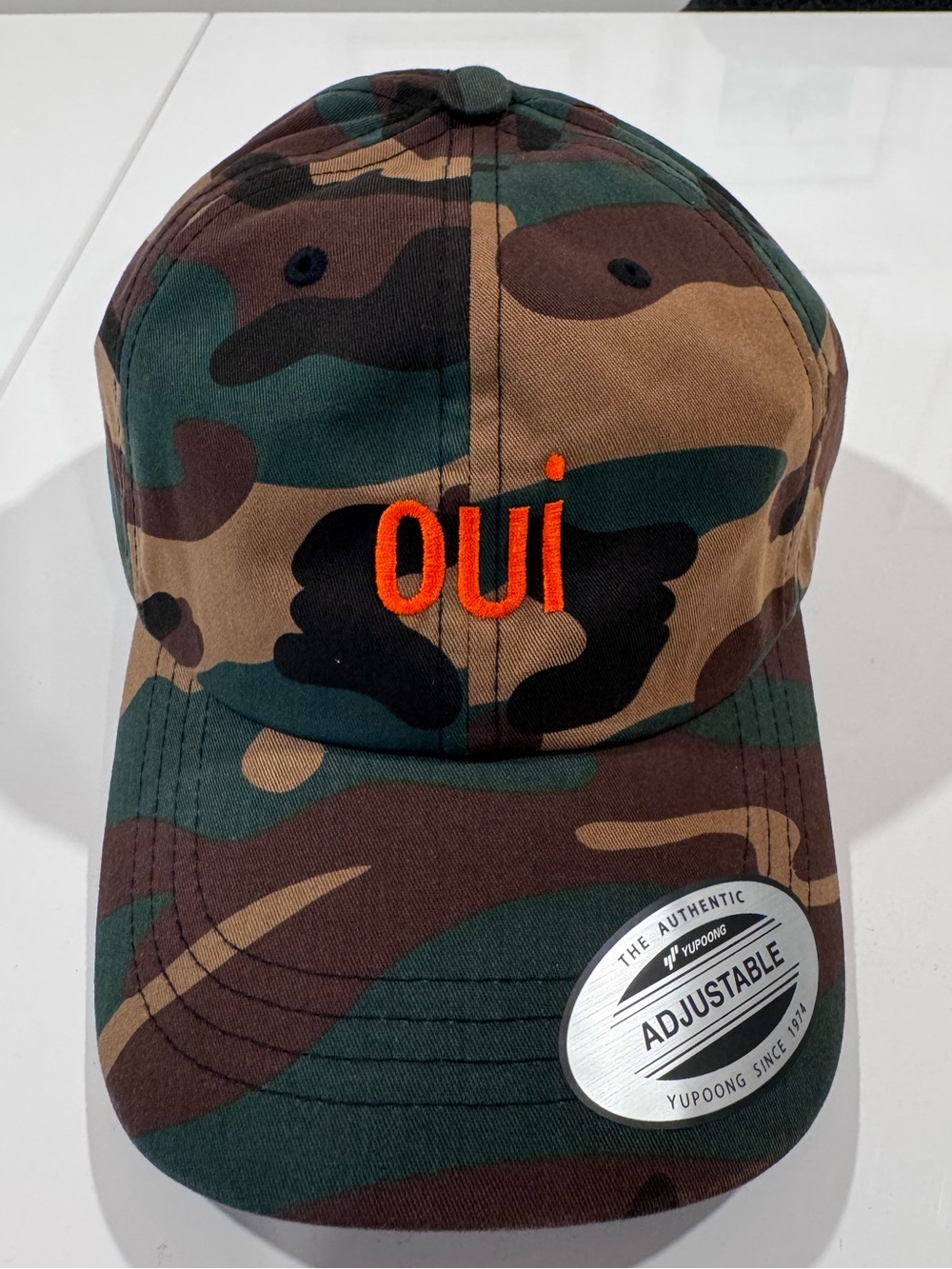 The Classic Camo Dad Hat with orange oui embroidery